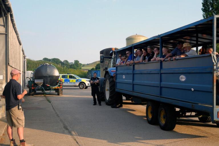 A tractor load of visitors listening to a presentation on the farm