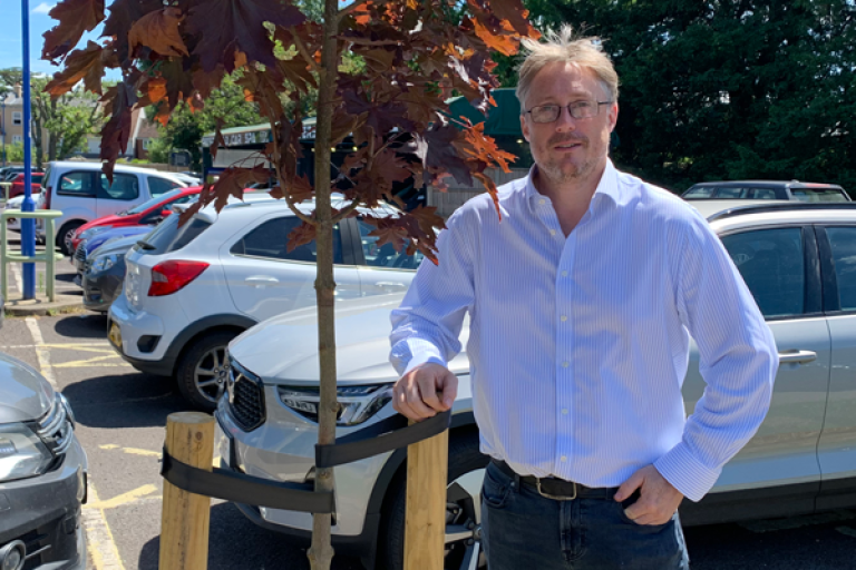 Cllr Millard next to a tree in Central Car Park, Petersfield